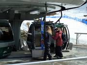 The employees place the skis in the gondola