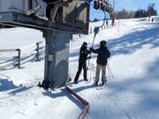 The pole is handed to skiers at the button lift
