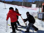 Poles are handed to skiers at the tow lift