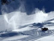 Snow cannons and snow groomer in operation