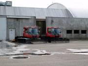 The two snow groomers in front of the ski hall