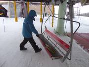 The seat is swept free of snow with a broom at the entry.