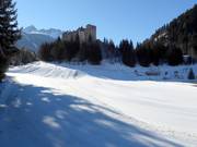 Ice skating rink and toboggan slope below Naudersberg Castle in Nauders