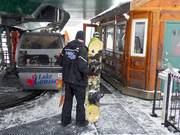 The winter sports equipment is loaded onto the gondola lift.