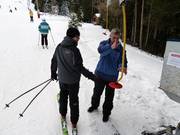The staff assists with boarding the platter lift.