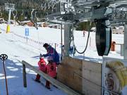 Staff assist with boarding at the button lift