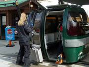 The staff place the skis in the gondola.
