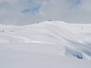 Thick snow cover on the grassy mountains of Les Sybelles
