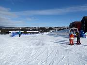 Practice slope with conveyor belt at the mountain station of the gondola lift