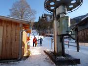 The staff assists with boarding at the drag lift.