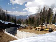 The construction work leaves deep scars on the mountain slopes.