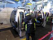 The staff assists with loading skis onto the gondola lift.