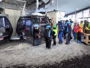 The staff assists with boarding the gondola lift.