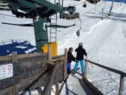 The staff assists with boarding at the platter lift.