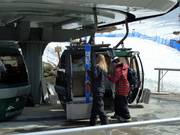 The staff place the skis in the gondola.