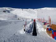 Conveyor belt of the ski school at the mountain station of the gondola lift