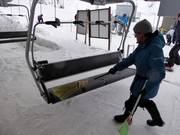 The seat is swept free of snow with a broom at the entry.