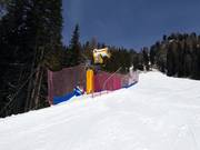 High-performance snow cannon on the valley run to Pozza di Fassa