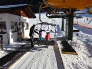 The staff assists with boarding the chairlift.