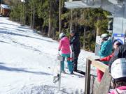 The staff assists with boarding the platter lift.