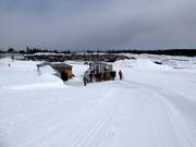 Take the snow groomer to the start of the toboggan run.