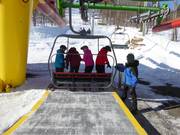 The staff assists with boarding at the chairlifts.
