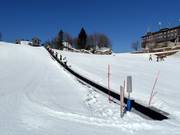 Practice slope with conveyor belt at the mountain station of the cable car