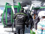 Staff assist with boarding at the gondola lift