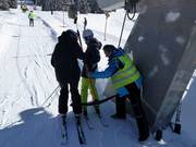 Poles are handed to skiers at the tow lift 