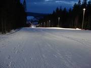 Freshly groomed night skiing slope